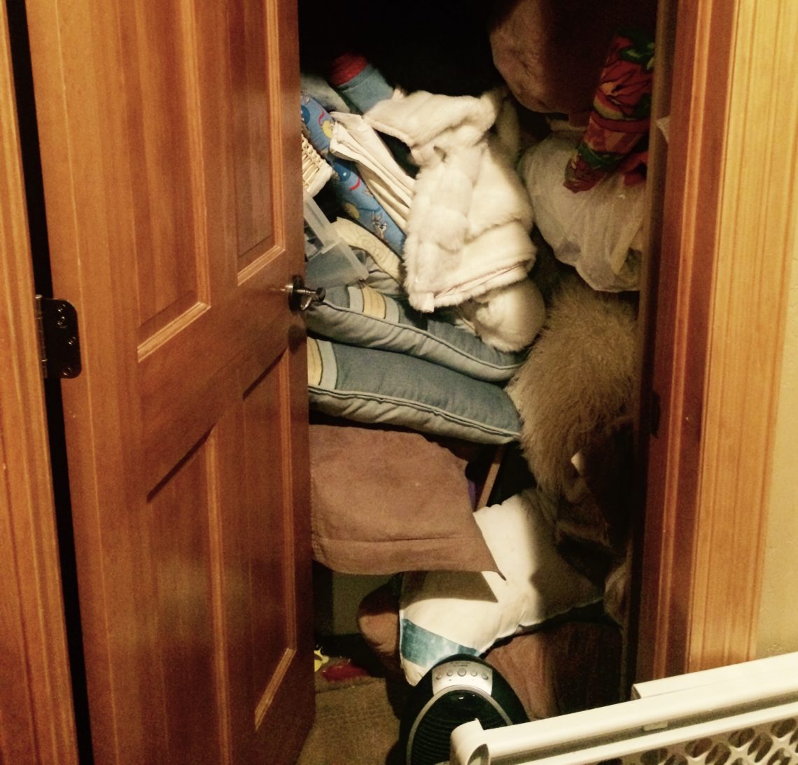 A disorganized closet with junk spilling out