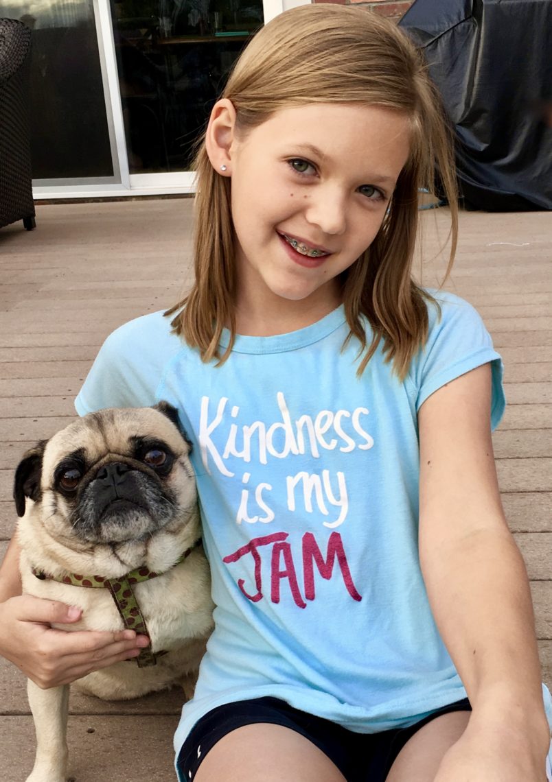 A little girl wears a t-shirt stating "Kindness is my jam."