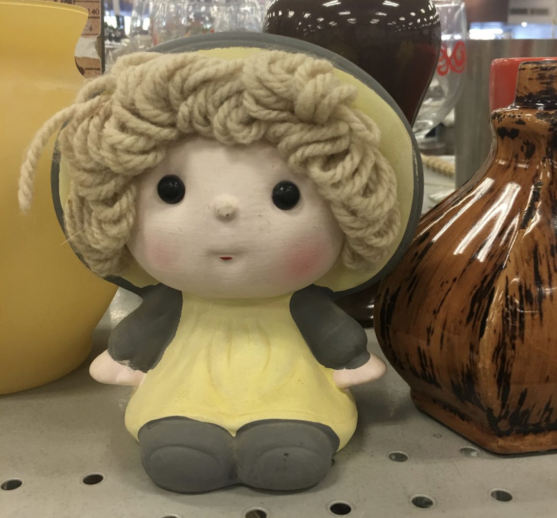 A ceramic doll with yarn hair at Goodwill