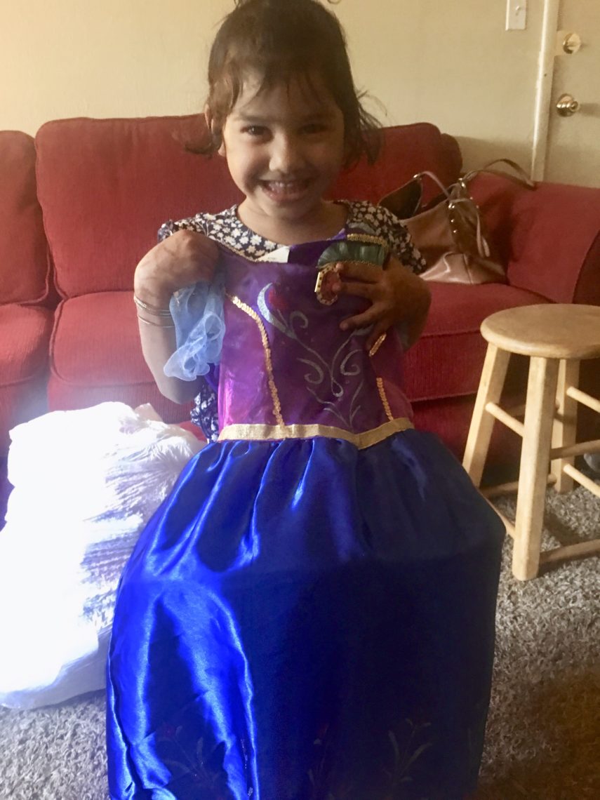 A Burmese girl holds up an Ana dress from Frozen