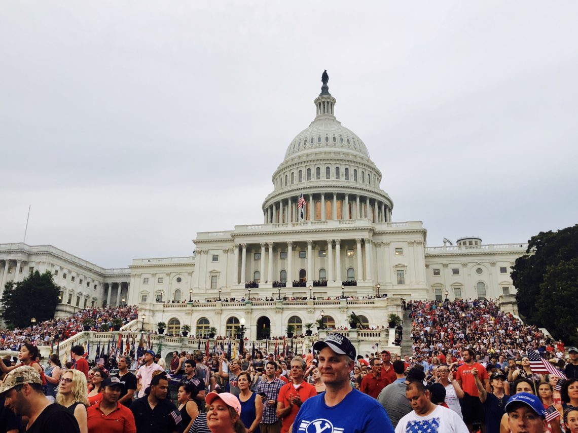 A picture of the capitol with tons of people around it.